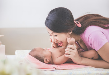 portrait of a mother happily playing with her baby after having