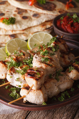 Indian chicken tikka on skewers close-up and naan. vertical
