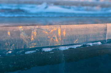slice of ice on the frozen lake at sunset