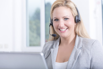 Hübsche Hotline Mitarbeiterin im Call Center lächelt