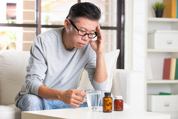 asian senior with severe headache and medicine