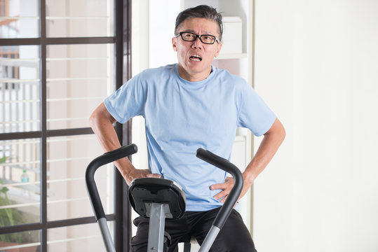 Asian Senior Male Panting Heavily On Exercise Bike