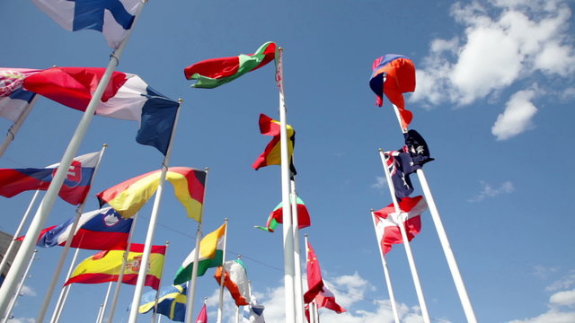 Sunny view at different flags on blue sky background