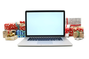 Christmas gifts with open laptop - online shopping concept