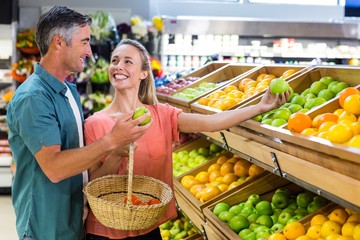 Happy couple holding an apple