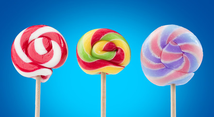 three striped lollipops isolated on blue background
