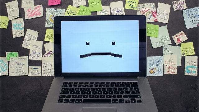 Laptop computer emotions and post-it papers sticked around