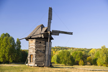 Fototapeta na wymiar Windmill standing in the field against the blue sky
