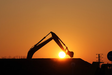 excavator on construction site silhouette