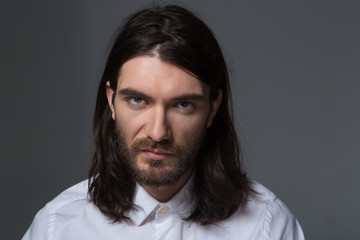Obraz premium Serious man with beard and long hair looking at camera