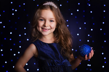 Naklejka premium Pretty girl is holding blue christmas ball