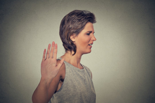 annoyed angry woman with bad attitude giving talk to hand gesture