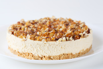 Homemade coconut cheesecake with caramel and assorted nuts