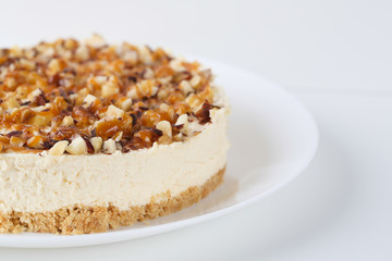 Homemade coconut cheesecake with caramel and assorted nuts