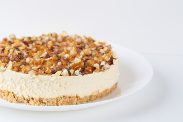 Homemade coconut cheesecake with caramel and assorted nuts