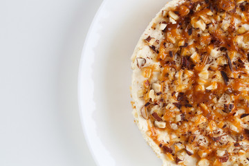 Homemade coconut cheesecake with caramel and assorted nuts