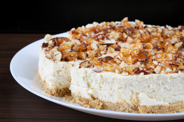 Homemade coconut cheesecake with caramel and assorted nuts