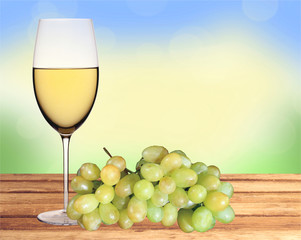 Glass of white wine and green grape on wooden table over nature
