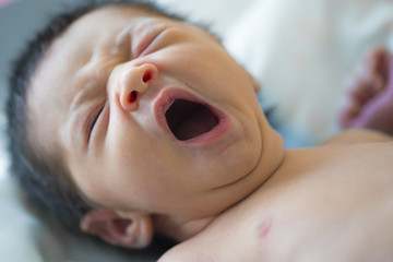 Bebé recién nacido bostezando después de la lactancia