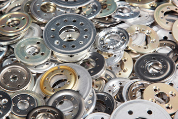 Pile of variety aluminum spacers and washers, industrial backgro