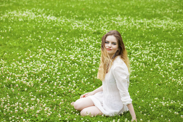 Young blonde woman on green meadow