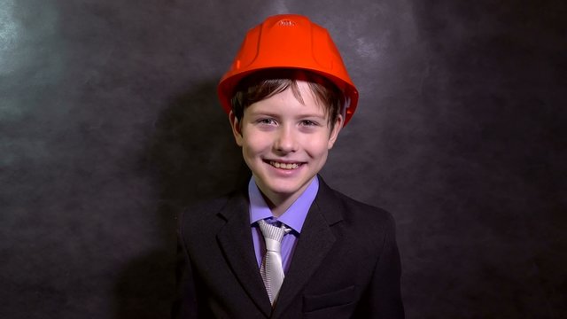 Teen boy builder in helmet smiling portrait