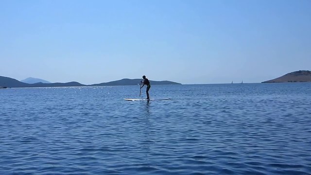 Une femme pratiquant le stand up paddle