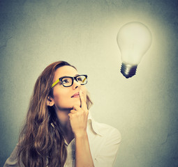 girl thinks looking up at bright light bulb