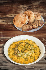 Russian Salad with Baguette and Pita Bread on Old Cracked Wooden Table