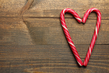 yummy Christmas candy lying on wooden brown background in the shape of a heart