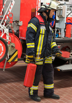 Feuerwehrmann im Einsatz mit einem Feuerlöscher in der Hand