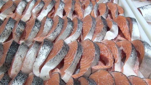 Fillet of red fish on boat in the snow on the shelves at shops and supermarkets. Fresh food, meat, bread, sausage, fruit, salad, seafood, sausage in modern shops and supermarkets for sale to buyers.