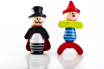 Still life di giocattoli di legno colorati su sfondo bianco pagliaccio e mago