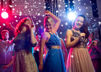 smiling friends dancing in club