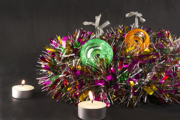 Big green and orange xmas ball with candle on tinsel