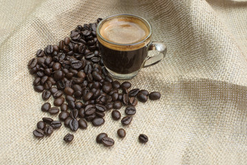 Shot of Espresso with beans on fabric