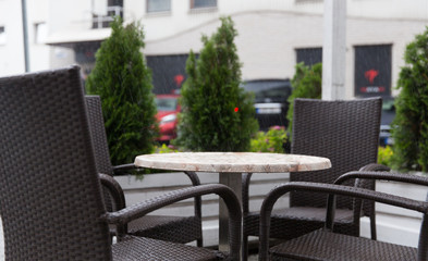 table and chairs on street cafe terrace under rain
