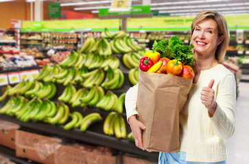 Woman with grocery bag of vegetables.