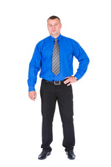 Confident business man. Successful businessman in blue shirt and tie holding hand on hip while standing against isolated white background. Concept of leadership and success
