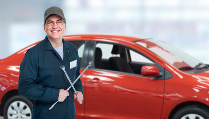 Auto mechanic with tire wrench in garage.