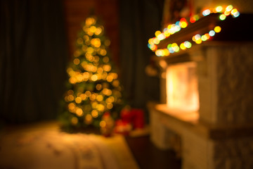 Blurred living room with fireplace and decorated Christmas tree