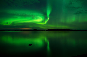 Northern lights over calm lake in Sweden (Aurora borealis)