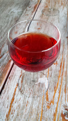 a glass of red wine on a wood table