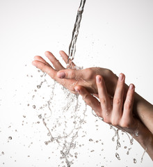 Closeup female hands under the stream of splashing water