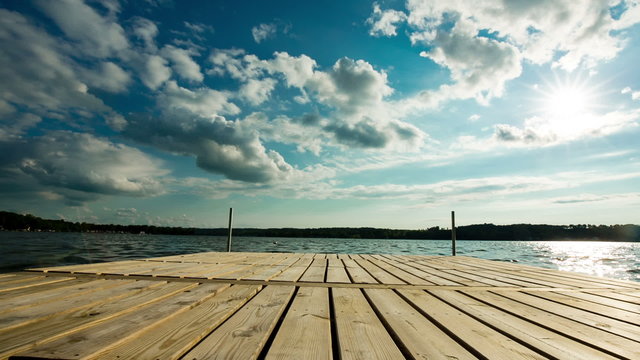 Residential Lake Dock Dolly with Sun. camera moves right and left on a large residential dock on a lake. beautiful sunny day in the summer.

