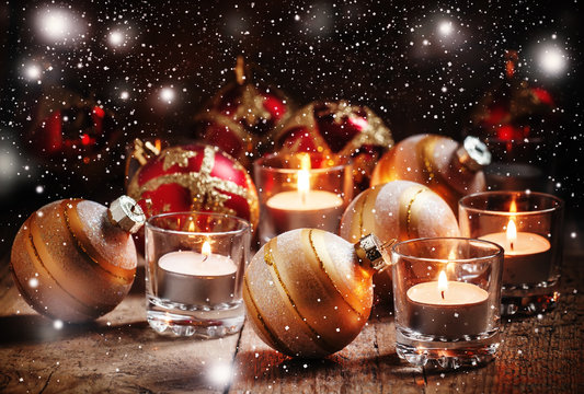 Christmas balls, burning candles on the old wooden background, d