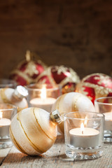 Christmas balls, burning candles on the old wooden background, d