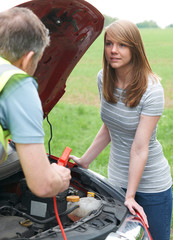 Fototapeta na wymiar Mechanic Helping Female Motorist With Flat Battery