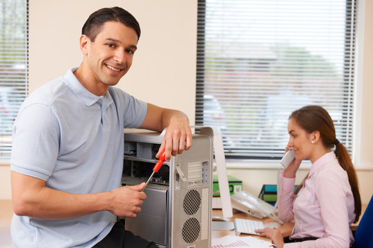 Computer IT Support Worker Fixing Machine In Office