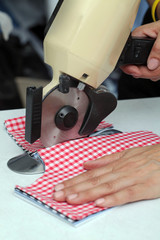 worker cutting out fabric for sewing